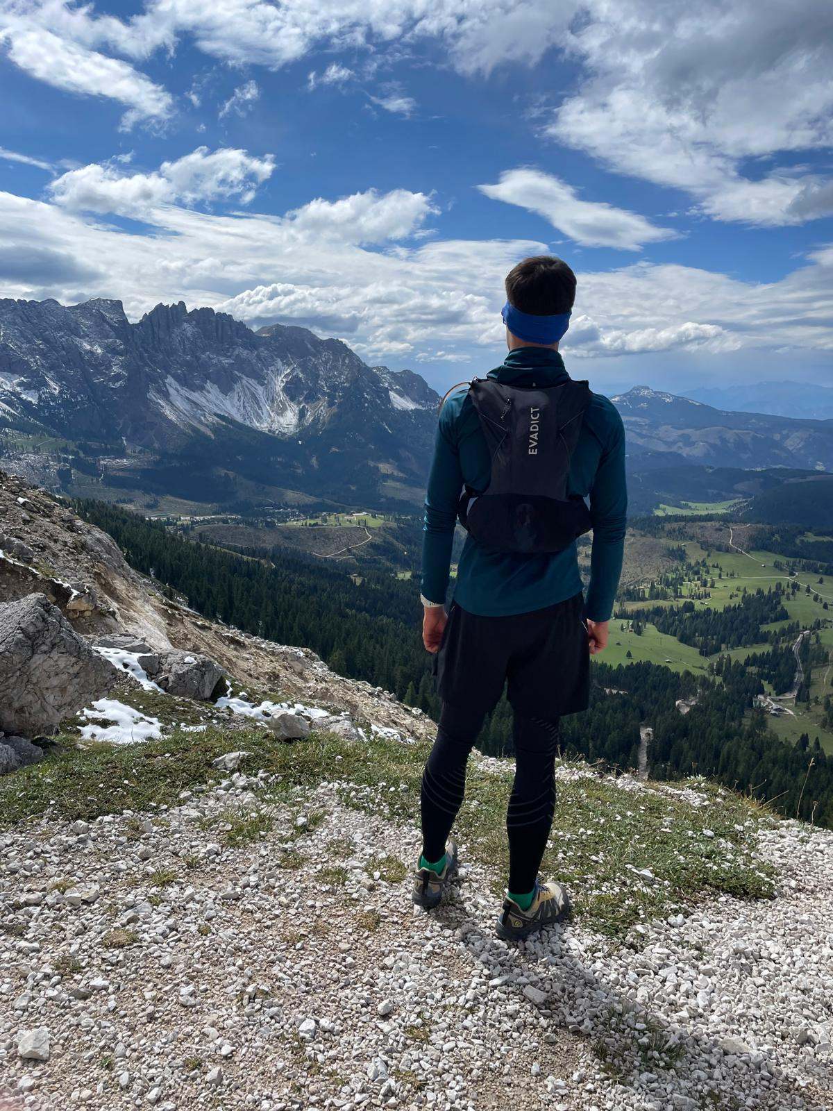 Läufer blickt von einem Grat auf ein Bergtal